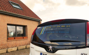 Voiture de j'habille vos fenêtres devant une maison
