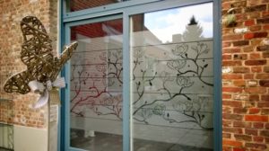 L’ADHÉSIF DÉPOLI POUR LES BAIES VITRÉES avec un motif de fleurs