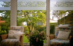 L’ADHÉSIF DÉPOLI POUR LES BAIES VITRÉES dans une veranda avec un motif de feuille